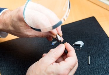 Man repairing hearing aid